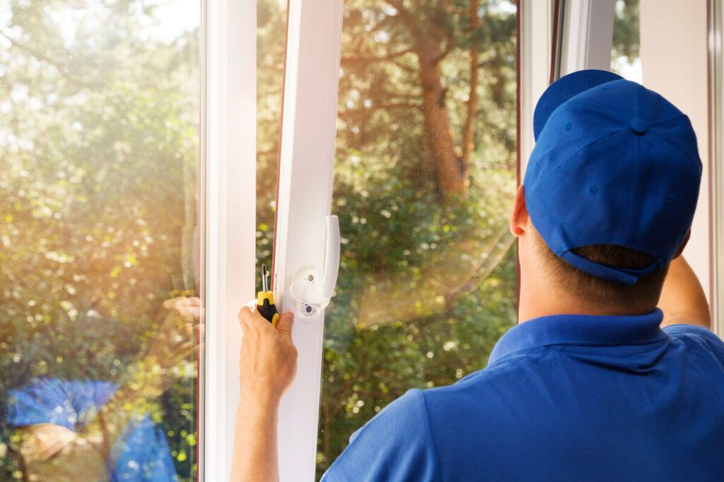 Professional window installer fitting a replacement window in a North Texas home.
